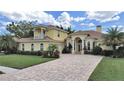 Beautiful home with a brick driveway, lush lawn, and mature landscaping at 1312 Fishing Lake Dr, Odessa, FL 33556