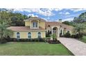 Well-manicured lawn, landscaped flower beds, and brick driveway enhance this charming home at 1312 Fishing Lake Dr, Odessa, FL 33556