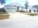 Charming single-story home with a well-maintained lawn and a two-car garage at 13231 Cherry Bark Cir, Riverview, FL 33579