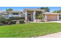 Attractive home featuring a lush green lawn, mature landscaping, and a two-car garage at 13553 Glaze Brook Dr, Hudson, FL 34667