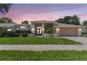 Beautiful single-story home with a well-manicured lawn, mature landscaping, and a two-car garage at 13553 Glaze Brook Dr, Hudson, FL 34667