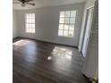 Clean bedroom with wood flooring, two windows, and ample natural light at 13909 Fletchers Mill Dr, Tampa, FL 33613