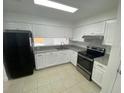 Well-lit kitchen with white cabinetry, modern appliances, and tile flooring at 13909 Fletchers Mill Dr, Tampa, FL 33613