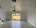 Bright living room with tile floors, ceiling fan and sliding glass doors to the backyard at 13909 Fletchers Mill Dr, Tampa, FL 33613