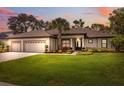 Charming home with a well-manicured lawn and a three-car garage, captured at sunset at 15615 Serengeti Blvd, Spring Hill, FL 34610