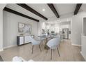 Open-concept dining room with modern chandelier, wooden beams, and light wood floors at 206 S Tampania Ave # 4, Tampa, FL 33609