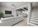 Bright living room with modern decor, neutral tones, ceiling fan, and staircase at 206 S Tampania Ave # 4, Tampa, FL 33609
