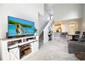 Bright, open-concept living room with a soaring ceiling, staircase and decorative rug at 3000 Jacob Crossing Ln, Holiday, FL 34691