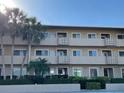 Multi-story condo building with open-air balconies and lush tropical landscaping in a desirable area at 3400 Gulf Blvd # 102, Belleair Beach, FL 33786