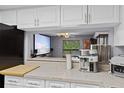 Open concept kitchen with bright cabinets looking into a movie room at 3709 Greenery Ct # 209, Tampa, FL 33618