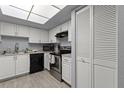 Well-lit kitchen with white cabinets, black appliances, and tiled flooring at 3709 Greenery Ct # 209, Tampa, FL 33618