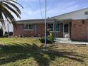 Close-up view of a well-maintained brick home with cute blue shutters and a cozy front porch area at 3850 Sablewood Dr, Holiday, FL 34691