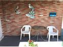 Cozy covered patio with brick wall, adorned with wall art and equipped with table and chairs for outdoor relaxation at 3850 Sablewood Dr, Holiday, FL 34691