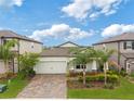Exterior home view showcasing a stunning view, paver driveway, and manicured lawn at 5059 Bromeliad Ave, Wimauma, FL 33598