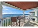 Relaxing balcony with table and seating overlooking the expansive water views at 5102 Coquina Key Se Dr # D, St Petersburg, FL 33705