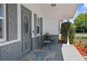 Inviting covered front porch with seating, a decorative rug, and a well-maintained exterior at 5117 Fitchburg Dr, Holiday, FL 34690
