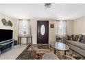 Inviting living room featuring comfortable seating, a patterned rug, and a front door at 5117 Fitchburg Dr, Holiday, FL 34690