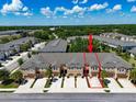 Aerial view of townhome with red arrow highlighting the property and showing parking at 6225 Scarlet Darter Way, Tampa, FL 33625