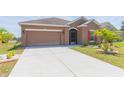 The exterior showcases a well-maintained lawn and an expansive driveway, perfect for multiple vehicles at 711 Parker Den Dr, Ruskin, FL 33570