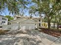 Elegant home featuring a three-car garage and well-maintained landscaping, creating curb appeal at 8114 Pond Shadow Ln, Tampa, FL 33635