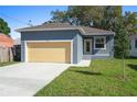 A charming home with a well-maintained lawn, an attached garage, and a yellow door at 936 57Th N Ave, St Petersburg, FL 33703