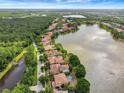 Stunning aerial view of waterfront homes along a lake, showcasing the community's lush landscaping at 9630 Tree Tops Lake Rd, Tampa, FL 33626