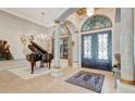 Elegant foyer with marble pillars, chandelier, tile floors, and view of the living area at 9630 Tree Tops Lake Rd, Tampa, FL 33626