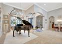 Spacious foyer with piano, arched doorways, tile flooring, and decorative columns at 9630 Tree Tops Lake Rd, Tampa, FL 33626