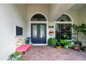 Elegant front entrance featuring double doors with decorative glass and a charming pink bench at 9630 Tree Tops Lake Rd, Tampa, FL 33626