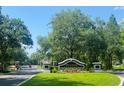 Entrance to Westpark Preserve featuring a sign, landscaping, gate and mature trees offering a peaceful setting at 10121 Westpark Preserve Blvd # 10121, Tampa, FL 33625