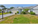 Attractive single-story home with a well-kept lawn, mature landscaping, and a gray brick driveway at 1016 Mcdaniel St, Sun City Center, FL 33573