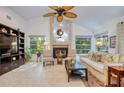 Comfortable living room featuring a fireplace with tile surround, large windows, and neutral decor at 10321 Shady Oak Ln, Seminole, FL 33777