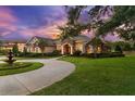 A beautifully landscaped home features a circular driveway, fountain, and stone accents at 10614 Low Oak Terrace, Thonotosassa, FL 33592