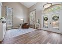 Elegant living room boasts soaring ceilings, wood floors, and natural light from the large windows at 12712 Stanwyck Cir, Tampa, FL 33626