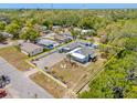 Aerial view showcasing the property with a fenced yard, two buildings, tropical landscaping, and parking at 1322 Idlewild Dr, Clearwater, FL 33755
