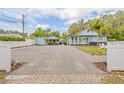 Charming blue home featuring ample parking, tropical landscaping, and guest cottage at 1322 Idlewild Dr, Clearwater, FL 33755