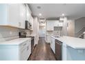 Modern kitchen featuring stainless steel appliances, white cabinetry, quartz countertops, and hardwood floors at 1526 W Arch St, Tampa, FL 33607