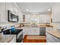 Bright kitchen featuring granite countertops, stainless steel appliances, and modern white cabinetry at 1666 S Lake Ave # 1, Clearwater, FL 33756