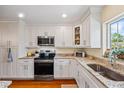 Well-lit kitchen featuring granite countertops, stainless steel appliances, and white cabinetry at 1666 S Lake Ave # 1, Clearwater, FL 33756