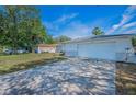 View of the driveway and two-car garage with well maintained lawn at 1710 Hibiscus N Cir, Oldsmar, FL 34677