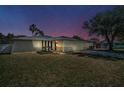 Charming single-Gathering home with a well-maintained lawn, a two-car garage, and mature landscaping under a dusky sky at 1710 Hibiscus N Cir, Oldsmar, FL 34677