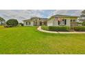 Inviting home with manicured lawn, stone accents, arched windows, and an American flag at 18423 Lithia Towne Rd, Lithia, FL 33547