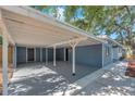 Spacious carport with direct home access, painted beams, and a concrete floor at 2003 E Clinton St, Tampa, FL 33610