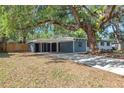 Single story home with long driveway, carport, mature trees, and manicured front lawn at 2003 E Clinton St, Tampa, FL 33610