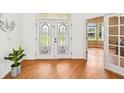 Bright entryway features double glass doors, wood floors, and white walls leading to adjacent rooms at 21019 Lonesome Acre Rd, Wimauma, FL 33598