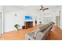 Inviting living room with wood floors, a cozy sofa, entertainment center and lots of natural light at 21019 Lonesome Acre Rd, Wimauma, FL 33598