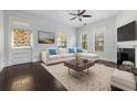 Bright living room with a decorative fireplace, ceiling fan, plush sofa, and natural light at 2810 N Jefferson St, Tampa, FL 33602