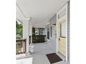 Inviting porch with classic columns and a sunny yellow door, perfect for relaxing and enjoying the outdoors at 2810 N Jefferson St, Tampa, FL 33602