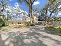 Charming two-story home with an expansive gravel driveway and covered carport at 315 Wooten Rd, Lutz, FL 33548