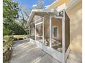 Enclosed sunroom with tile flooring, white trim and screen, and glass door leading into home at 315 Wooten Rd, Lutz, FL 33548